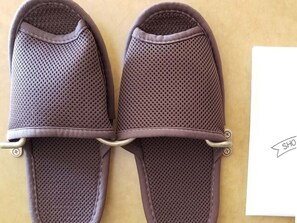 Un par de pantuflas marrones con diseño perforado y ojales metálicos.