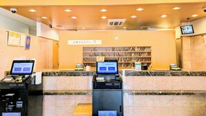 A hotel reception area with a 'FRONT' sign, a digital display, and a security camera. - Toyoko Inn Yokohama Shinkoyasu Ekimae (Yokohama)