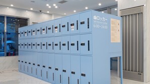 A row of blue self-service lockers with a sign indicating they are available from 6:00 to 24:00.