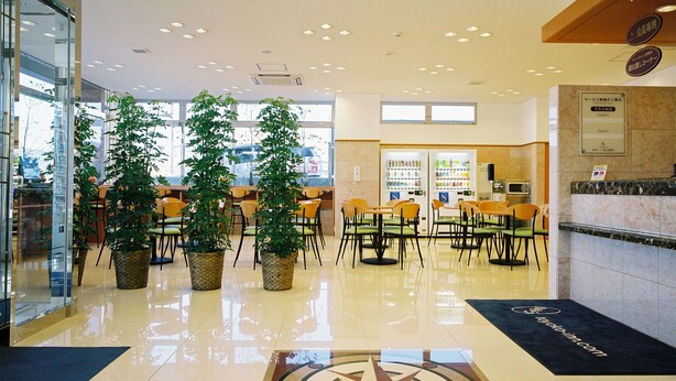 A spacious lobby with a polished floor, multiple seating areas, and large windows allowing natural light.