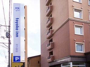 A building with a sign for Toyoko Inn, featuring a prominent 'P' parking sign, indicating a parking facility.