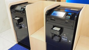 Deux bornes en libre-service dans le hall d’un hôtel.
