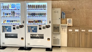 Deux distributeurs automatiques proposant une variété de boissons et d’en-cas, un distributeur d’eau et un panneau indiquant que l’on se trouve à l’endroit appelé « ICE ».