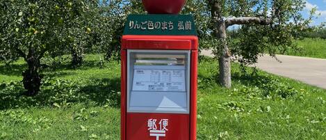 Un bureau de poste rouge, avec une enseigne verte et une sphère rouge sur le toit.