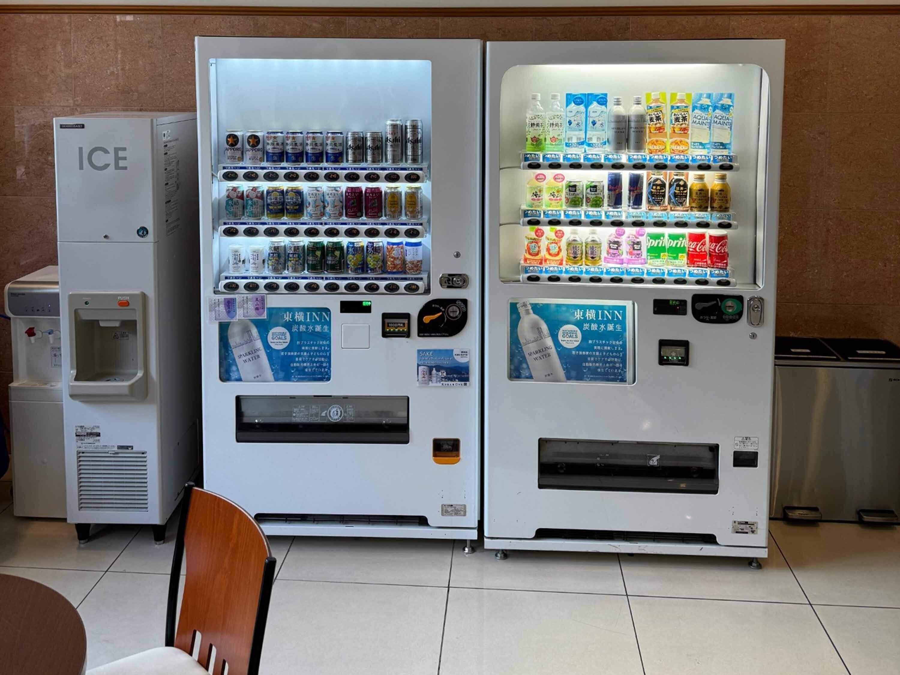 Deux distributeurs automatiques, l’un pour l’eau et l’autre pour les boissons, et les deux affichent des instructions en japonais.