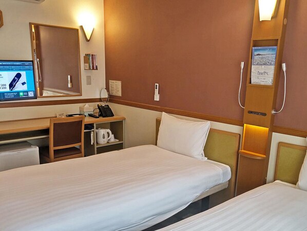 A hotel room with two beds, a desk, a telephone, a mirror, and a wall-mounted heater. - Toyoko Inn Atami Ekimae (Atami)