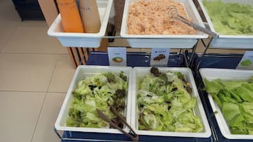 A buffet with various food options including salads, a tuna salad, and beverages.