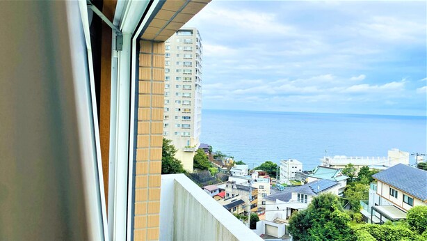 Ein Hochhaus mit Blick auf das Meer und ein Wohngebiet darunter.