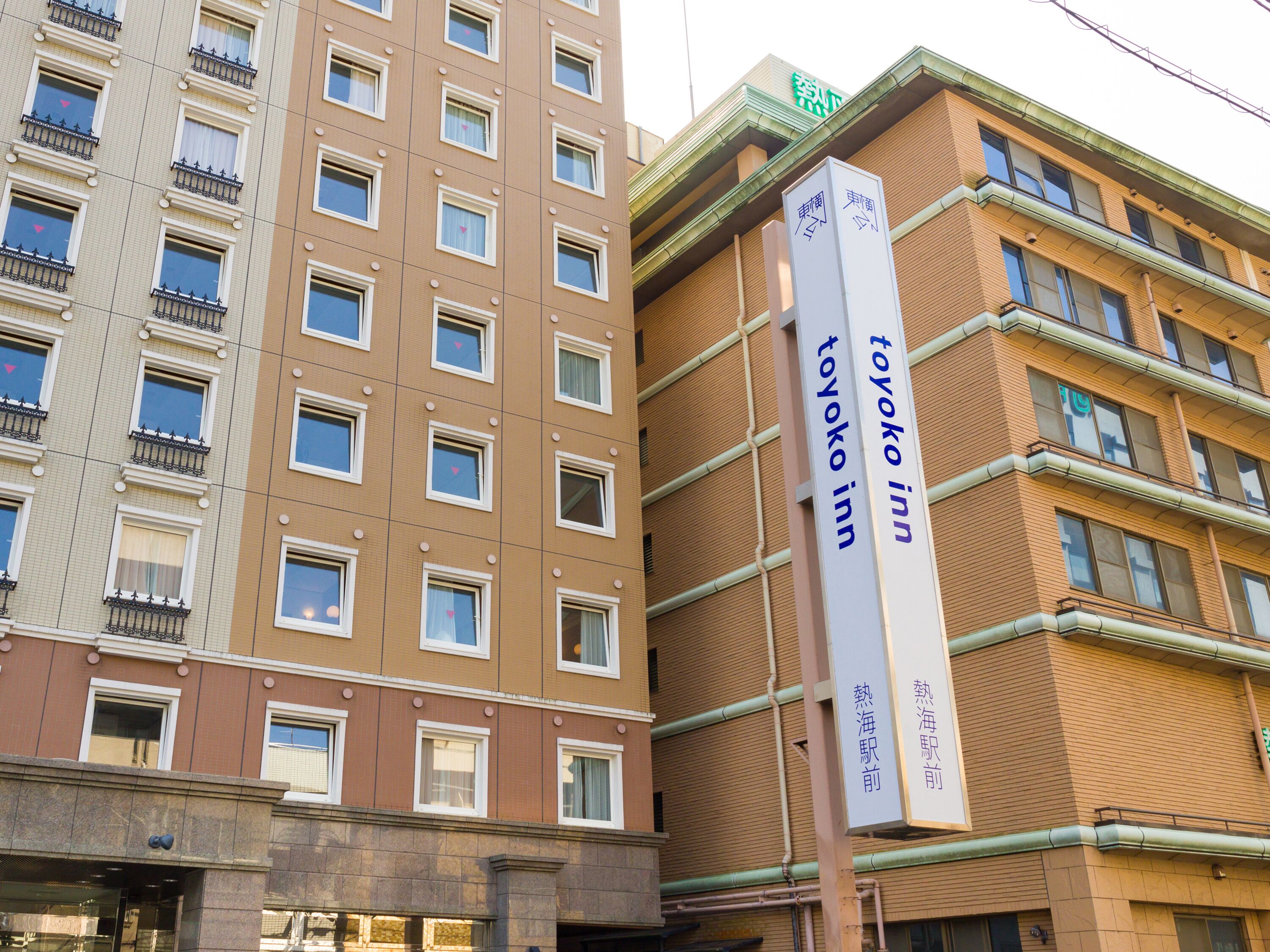 Een gebouw met een bordje waarop 'Toyoko Inn' staat, wat een hotel aangeeft.