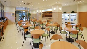 A spacious indoor dining area with multiple tables and chairs, a counter with a computer, and vending machines. - Toyoko Inn Kumamoto Ekimae (Kumamoto)