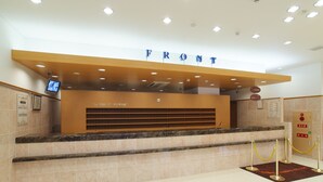 A reception desk with a 'FRONT' sign above it, a digital screen, and a bulletin board with notices. - Toyoko Inn Kumamoto Ekimae (Kumamoto)