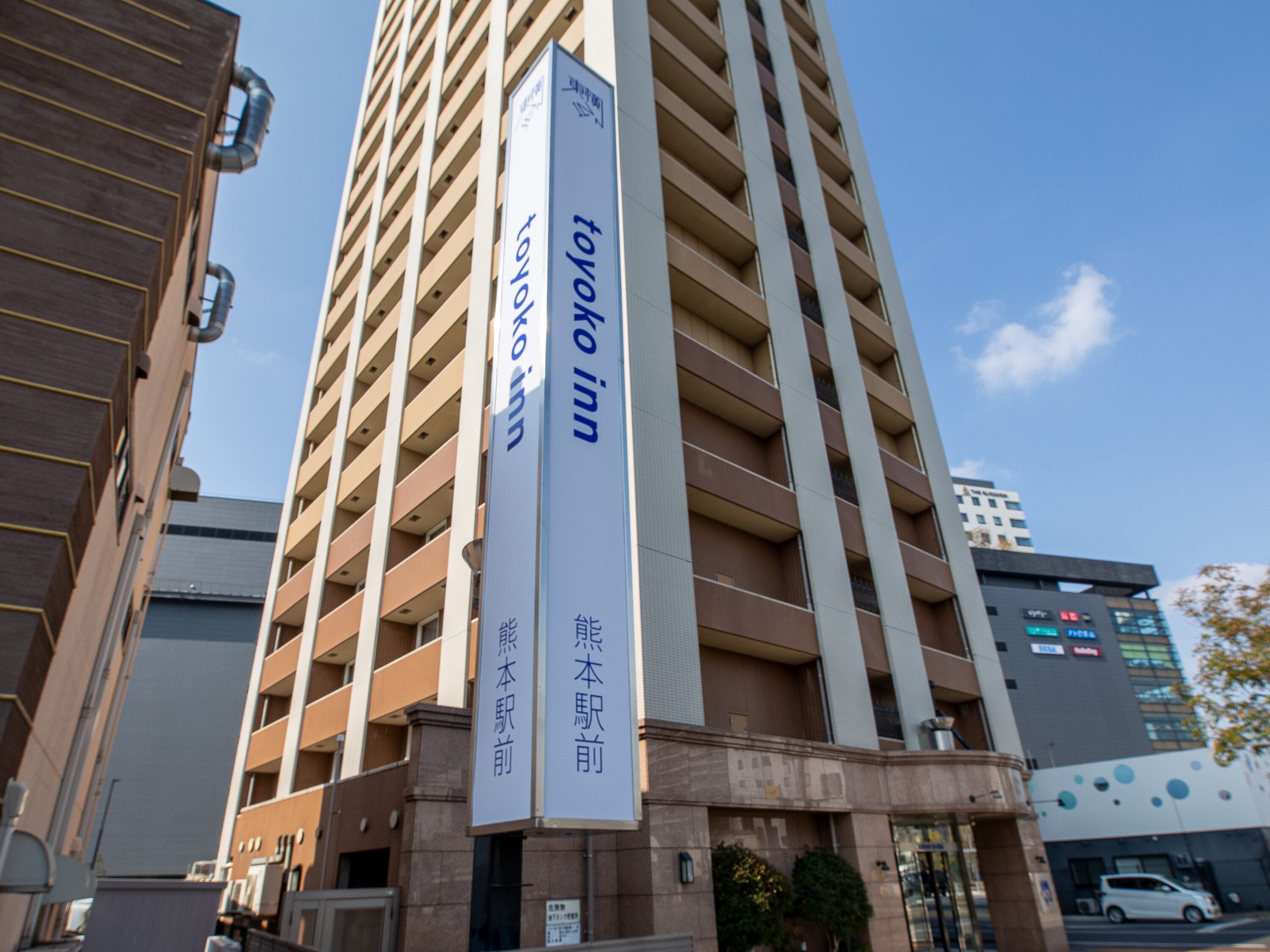 A tall building with multiple floors, featuring vertical lines and a modern architectural design.