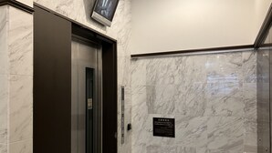 A modern elevator with a digital display, marble walls, and a sign indicating a specific floor. - Toyoko Inn Tokyo Nihombashi Mitsukoshi Mae A4 (Tokyo)