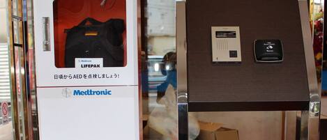 Un desfibrilador automático externo (DEA) y un panel de control en un espacio público interior.
