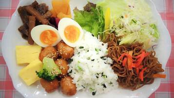 A plate of food with various items including rice, noodles, vegetables, and meat.