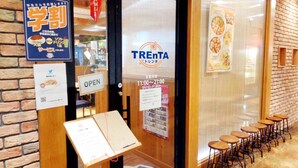 Entrada de un restaurante con un letrero que dice "OPEN" y un expositor de menú.