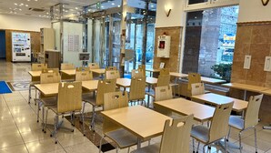 A cafeteria with multiple tables and chairs, a vending machine, and a fire extinguisher. - Toyoko Inn Wako-shi Ekimae (Wako)
