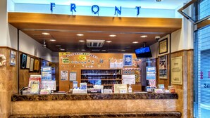 A reception desk with a marble counter, framed pictures, and various informational posters. - Toyoko Inn Shin-osaka Chuo-guchi Shinkan (Osaka)