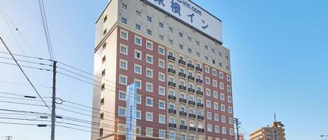 A multi-story hotel with a prominent sign at the top, featuring a website address.