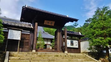 A traditional Japanese building with a wooden entrance and stone steps leading up to it.