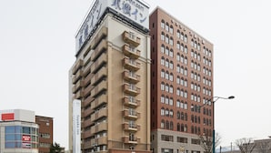 Un edificio de varios pisos con un cartel llamativo de 'toyoko inn' en la parte superior.