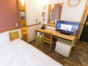 A hotel room with a bed, a desk with a computer, a mirror, a clock, and a small refrigerator. - Toyoko Inn Yamagata Station West (Yamagata)