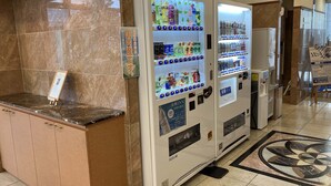Vestíbulo de hotel con una recepción, máquinas expendedoras y un letrero que indica un Club Toyoko Inn.