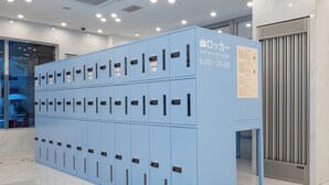 Una fila de taquillos azules de autoservicio, con un cartel que indica que están disponibles de 6:00 a 24:00.