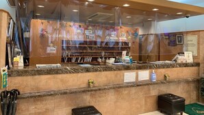 A reception area with a 'FRONT' sign, a counter with various items, and a security camera. - Toyoko Inn Matsue Ekimae (Matsue)