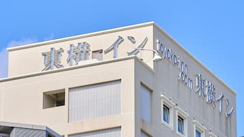 A building with a tiled facade and signage in both English and another script, indicating a commercial establishment.