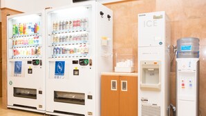A row of vending machines with various beverages and snacks, a water dispenser, and a small cabinet. - Toyoko Inn Miyazaki Ekimae (Miyazaki)