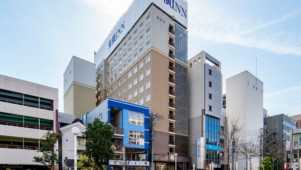 A multi-story building with signage for 'Toyo Inn' and 'Toyo Hotel'.