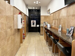A narrow hallway with a long counter, black tiled walls, and a fire extinguisher on the left. - Toyoko Inn Tokyo Tameike-sanno-eki Kantei Minami (Tokyo)