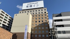 Een meerhoog gebouw met een opvallend bord voor Toyoko Inn.
