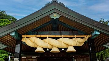 A traditional Japanese building with a large entrance and a covered area with hanging baskets.