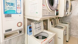 A laundry facility with multiple washing machines and a control panel with instructions. - Toyoko Inn Hachinohe Ekimae (Hachinohe)