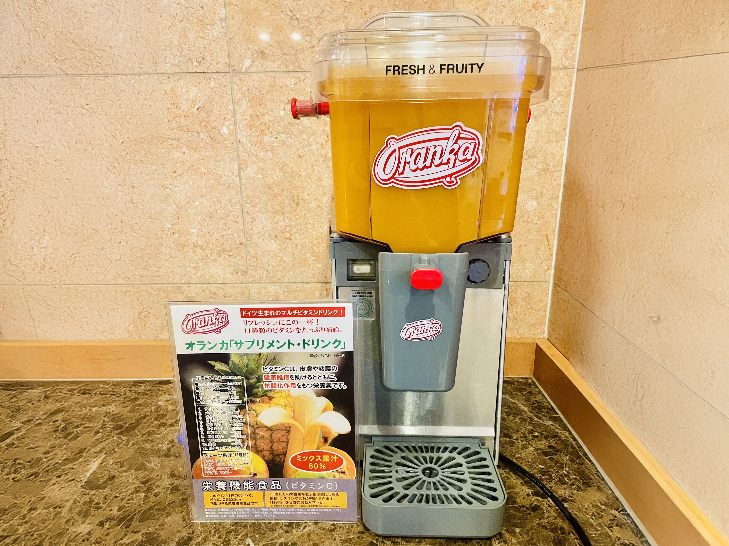Een drankdispenser met een label waarop staat dat het een mengsel van 60% vruchtensap tapt.