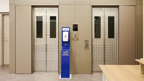 An elevator with a digital display and a blue sign indicating a Toyoko Inn. - Toyoko Inn Kawasaki Station Shiyakusho Dori (Kawasaki)