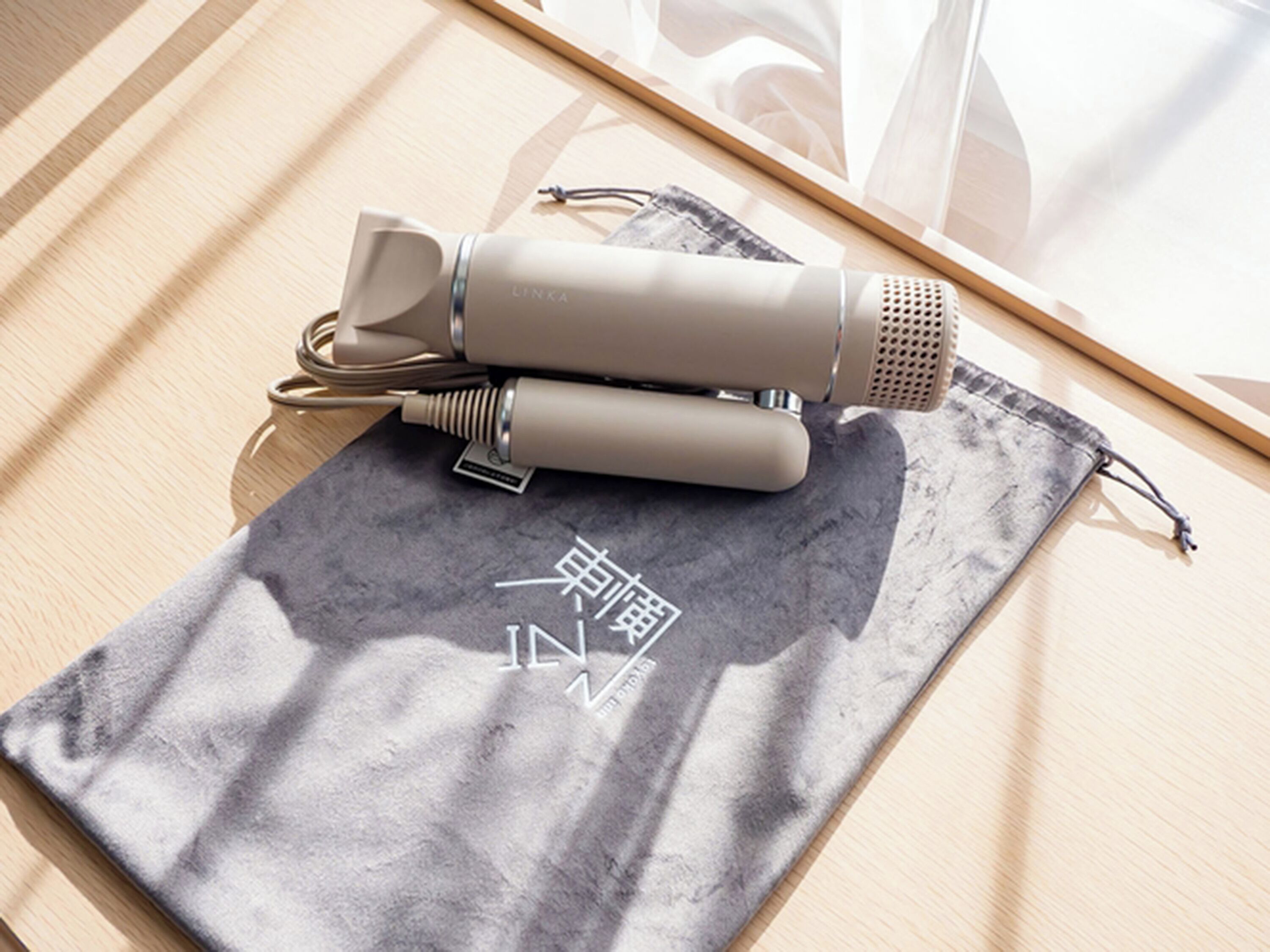 A microphone and its charging cable on a gray cloth with Chinese characters.