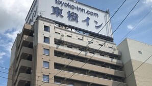 Een meerhoog gebouw met een bord voor 'toyoko-inn.com' en Japanse tekens.