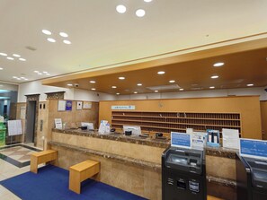 A hotel reception area with a marble counter, a wooden reception desk, a clock, and a self-service kiosk. - Toyoko Inn Niigata Ekimae (Niigata)