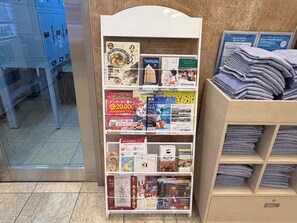 A bookstore with a variety of books and magazines, a display of folded towels, and a blue cabinet in the background. - Toyoko Inn Niigata Ekimae (Niigata)