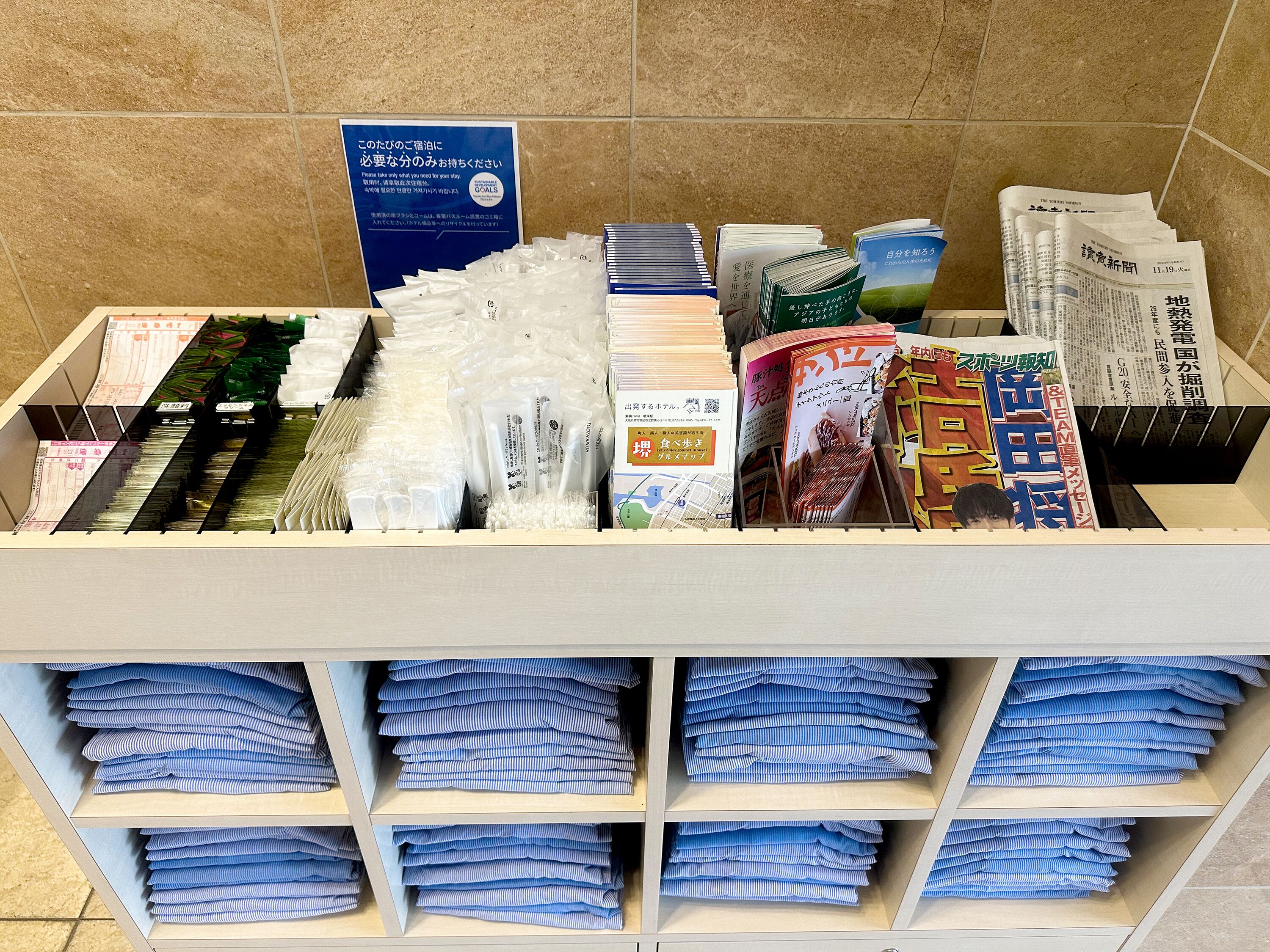 A storage area with neatly organized items including books, papers, and folded blue and white striped cloths.