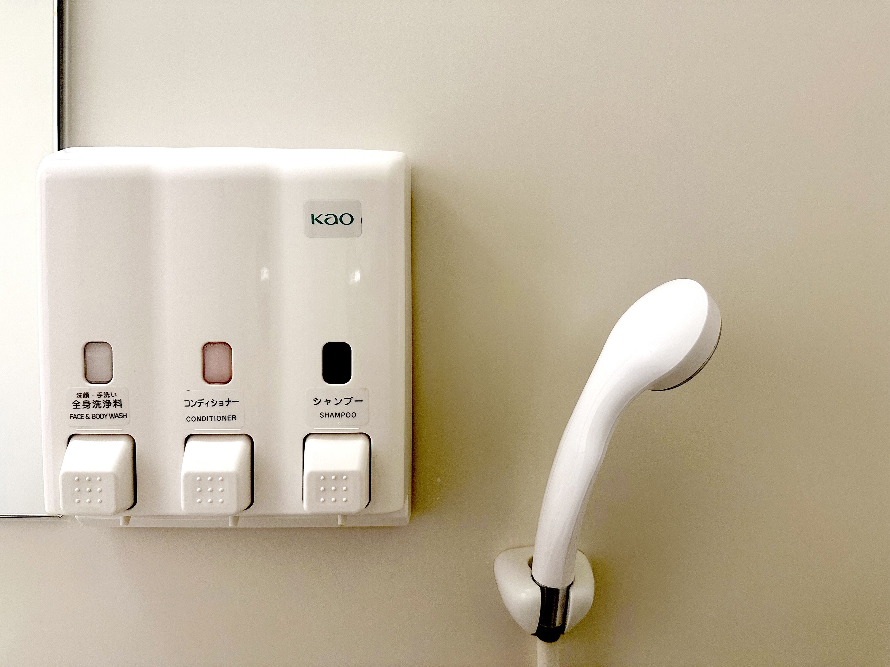 A wall-mounted control panel with buttons for face and body wash, conditioner, and shampoo.