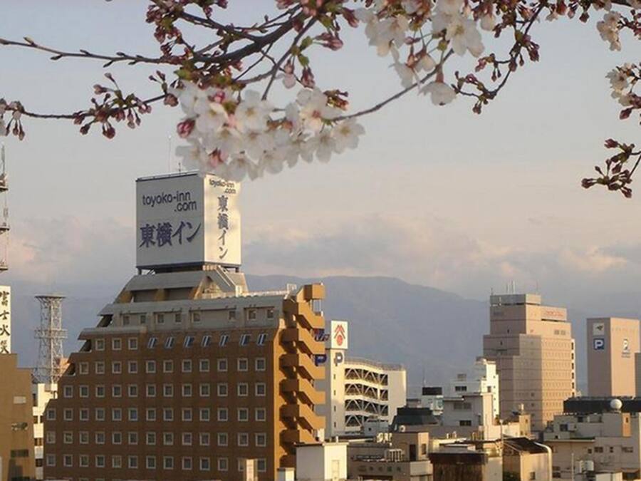 Un paisaje urbano con un edificio destacado que muestra un letrero para 'toyako-inn.com'.