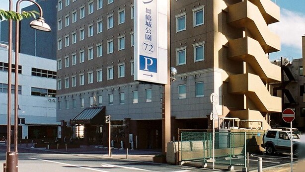 A multi-story building with a prominent sign indicating a parking area. - Toyoko Inn Kofu Station Minami 1 (Kofu)