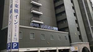 A multi-story building with a sign for 'Hotel Toyota Inn' and a parking sign indicating 'P' for parking. - Toyoko Inn Yokohama Stadium Mae No.2 (Yokohama)