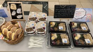 A table with various food items, including bread, rice, and packaged meals, displayed for sale. - Toyoko Inn Yokohama Stadium Mae No.2 (Yokohama)