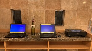 Two laptops on a marble countertop with a vase of flowers between them. - Toyoko Inn Yokohama Stadium Mae No.2 (Yokohama)