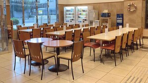 A spacious indoor dining area with multiple tables and chairs, vending machines, and a clock on the wall. - Toyoko Inn Kobe Sannomiya-eki Higashi (Kobe)